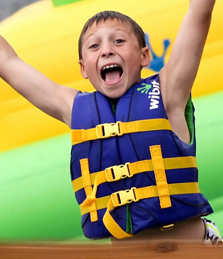 happy boy camper in a lifevest